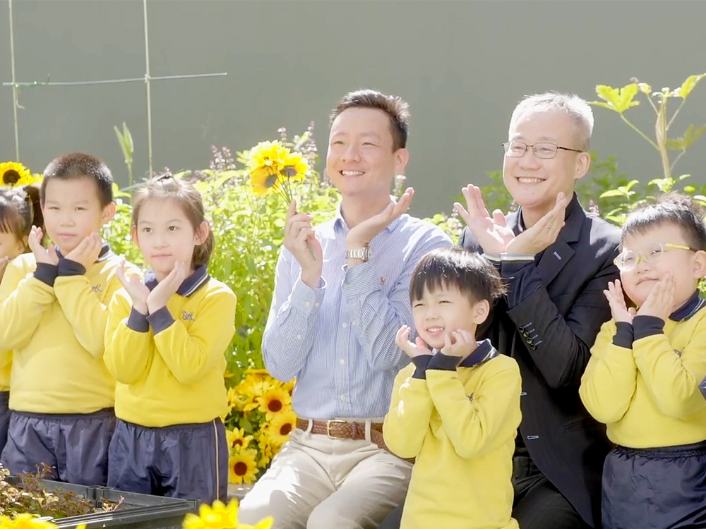Photo with students beside sunflowers at school